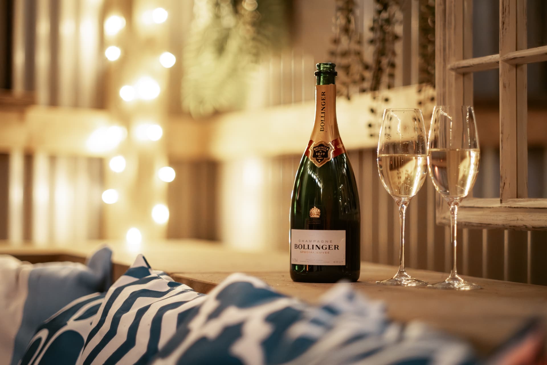 Champagne and two flutes on the window ledge of The Bothy, fairy lights glowing behind